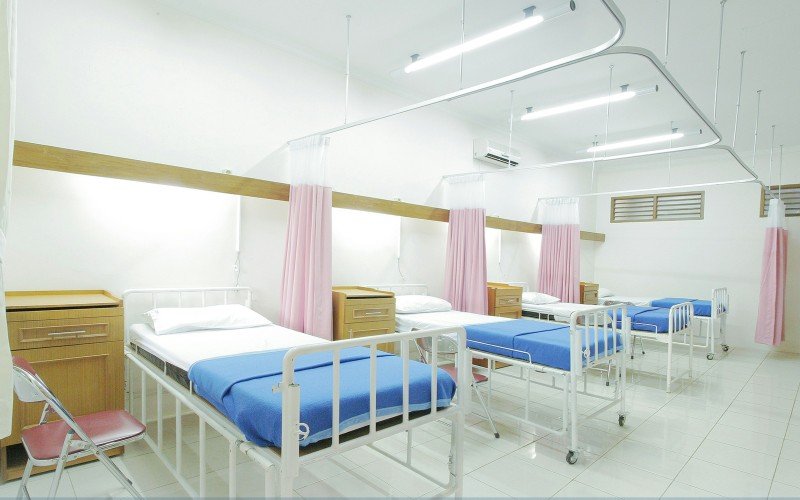 Modern hospital patient rooms with clean beds and privacy curtains