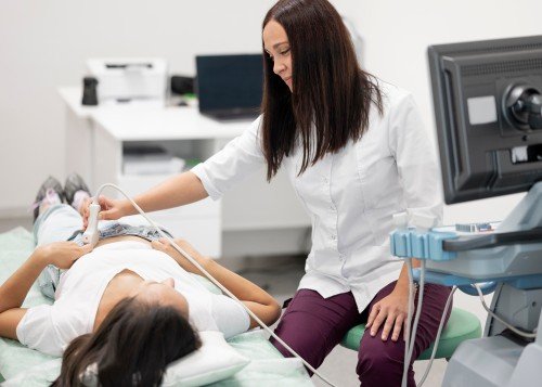 Gynaecologist performing an ultrasound examination on a female patient in a medical clinic