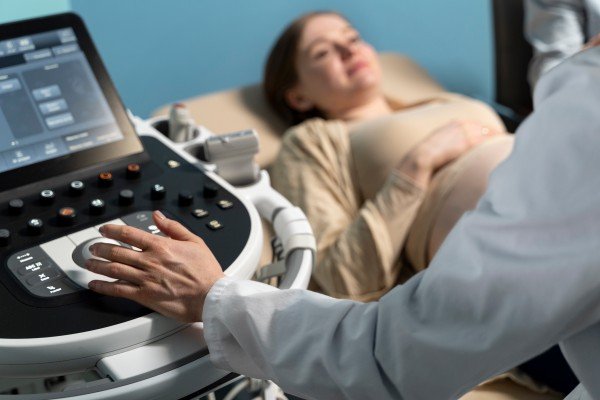 Gynaecologist performing an ultrasound examination on a pregnant woman in a medical clinic